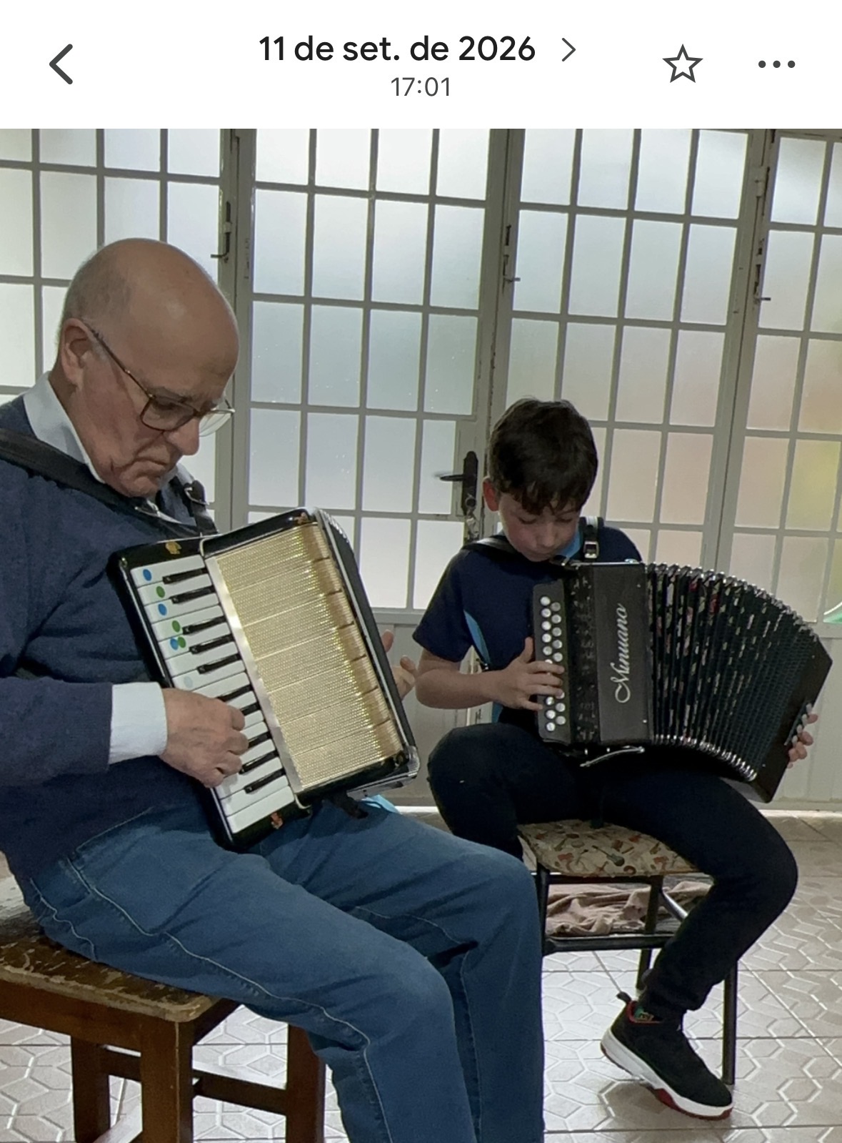 Avô e neto tocando acordeon juntos