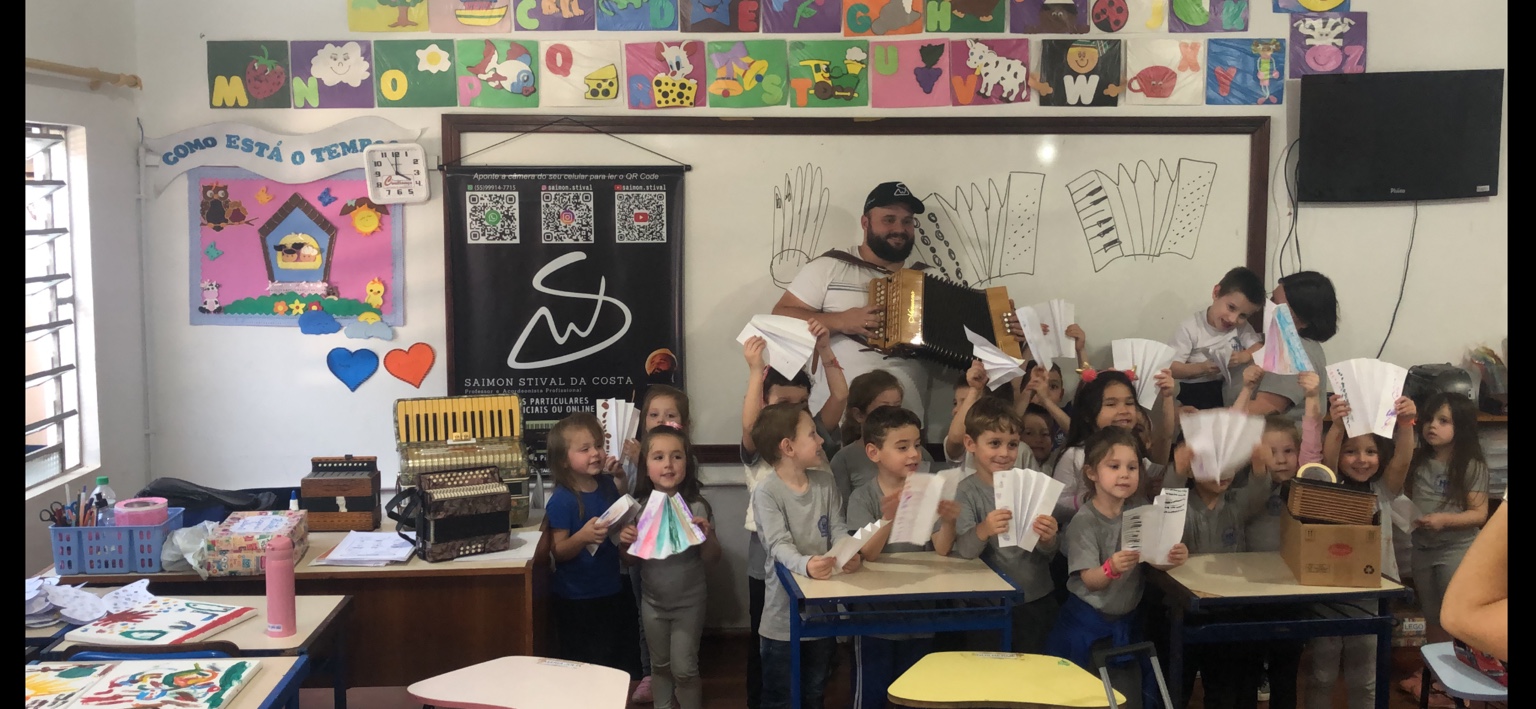 Saimon Stival com crianças em uma atividade musical escolar